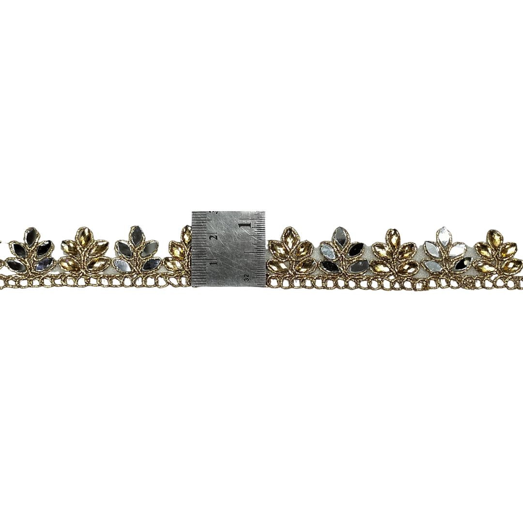 Decorative gold and silver trim with leaves and stones on a white background